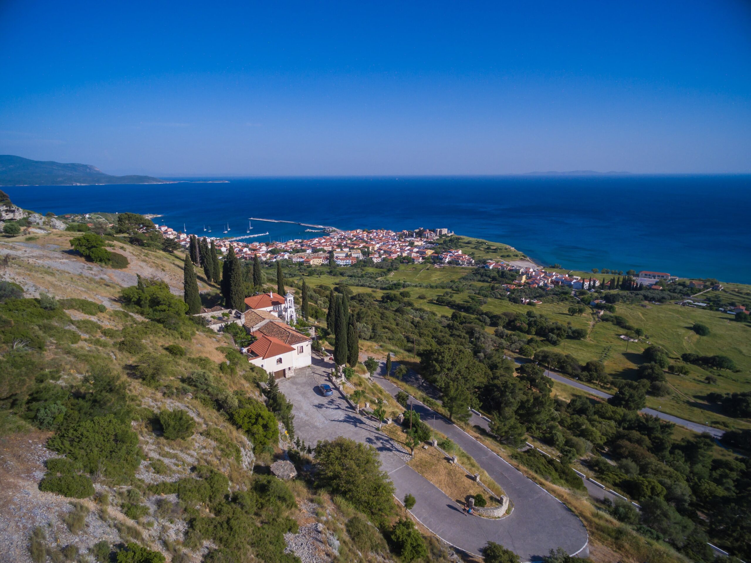 Aerial view of coastal village with lush greenery and sea in Cyprus, ideal for real estate investment