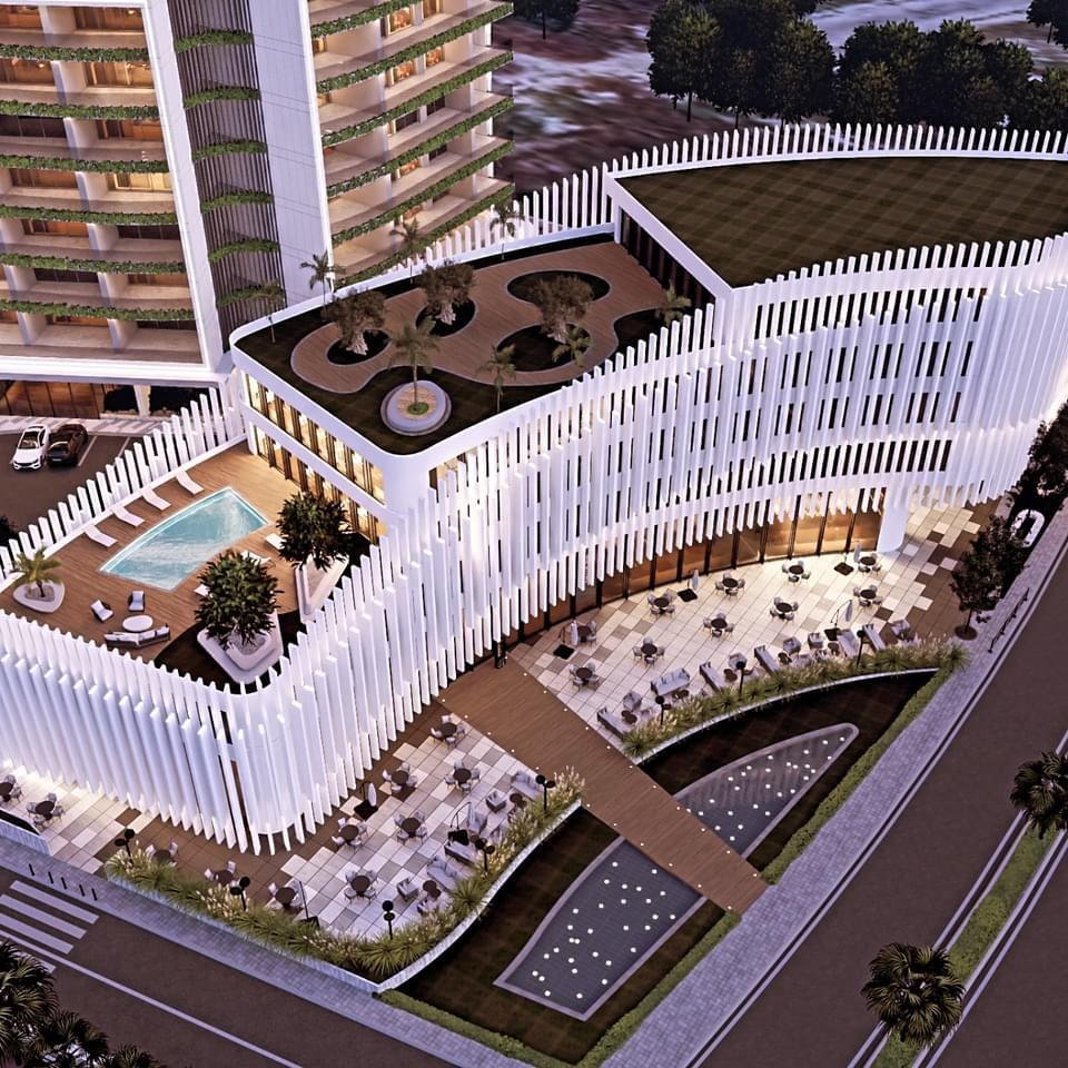 Top view of a modern development project in Cyprus featuring rooftop greenery, a pool, and outdoor seating areas