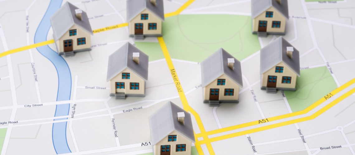 Miniature houses placed on a city map representing real estate options in the Larnaca property market.